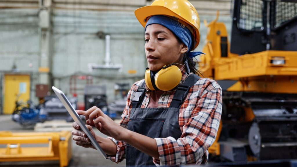 Woman Diesel Mechanic using IPad to check diagnostic codes of assets