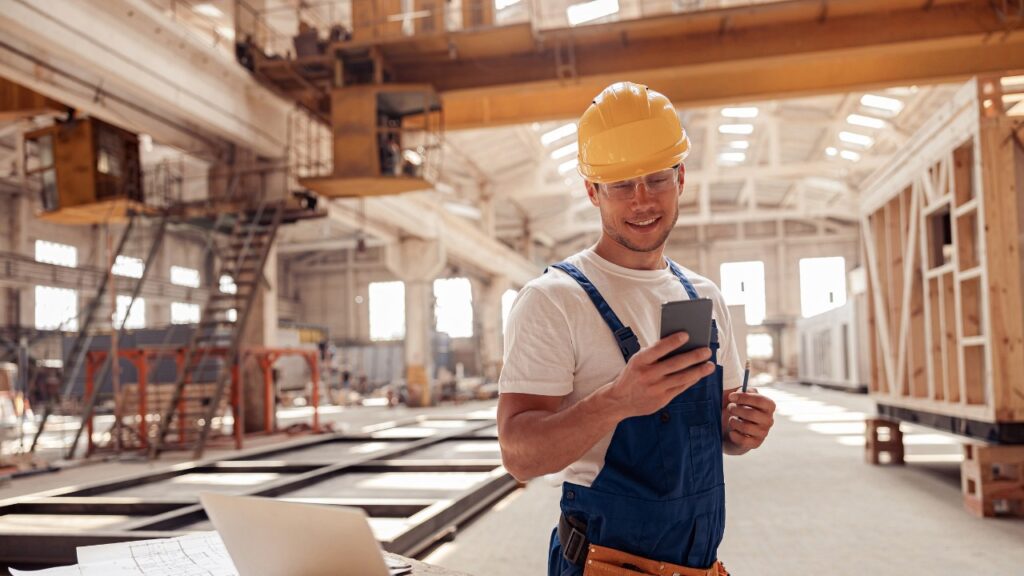 Construction worker using telematics to check status of fleet