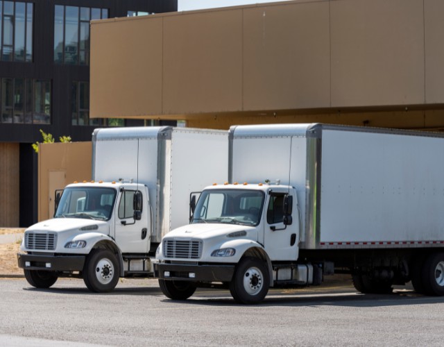 Two heavy duty vehicles loading up at a distribution warehouse