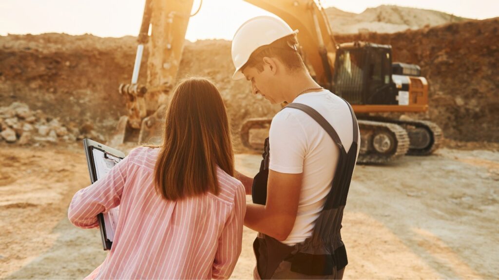 Operator working with engineer to learn how to use IoT technology on construction site