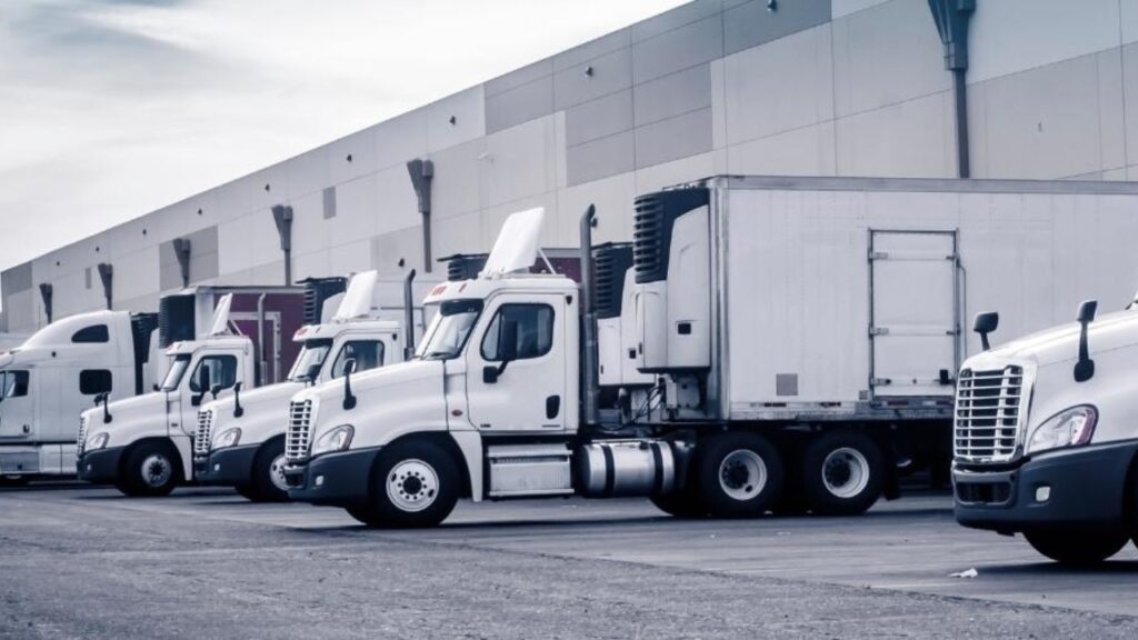 Class 8 Vehicles and trailers loading at a warehouse.