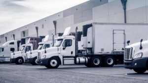 Class 8 Vehicles and trailers loading at a warehouse.